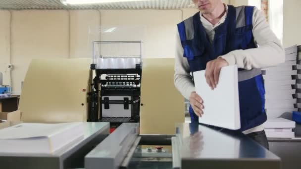 Trabajador en la imprenta se dedica a la impresión — Vídeo de stock