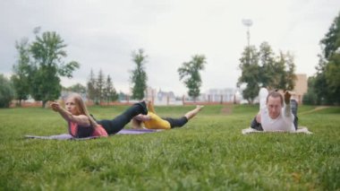 Üç genç sporcuların pratik yoga Park
