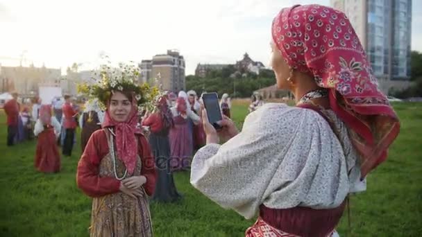 Kazan, Rusia, 19 de julio de 2017, Una mujer en traje popular está fotografiando el conjunto de música étnica rusa — Vídeos de Stock