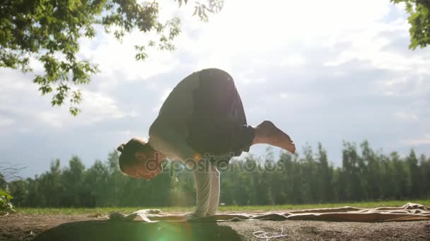 Силуэт инструктора по фитнесу, практикующего йогу в утреннем парке на рассвете — стоковое видео
