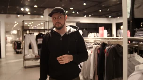 Jongeman is het kiezen van GLB in mall of kledingwinkel - winkelen, mode, stijl — Stockvideo