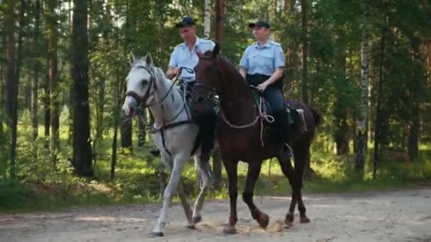 Казань, Россия - 28 июля 2017: Полиция - мужчина и женщина - на лошадях в лесу — стоковое видео