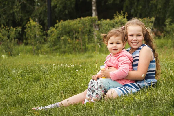 Happy little sisters - portrét v parku — Stock fotografie