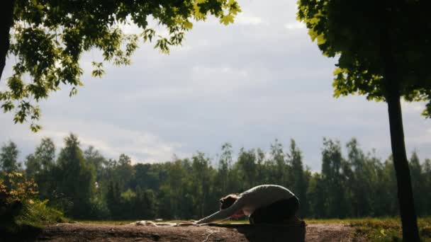 Yoga buiten in park - man alleen is opleiding bij morning, silhouet — Stockvideo