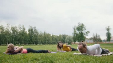 Üç genç modelleri sporcular pratik yoga Park