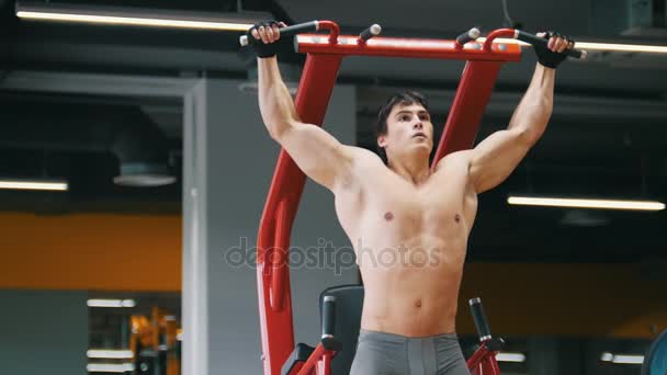 Jeune sportif masculin se gare dans une salle de gym, club de fitness — Video