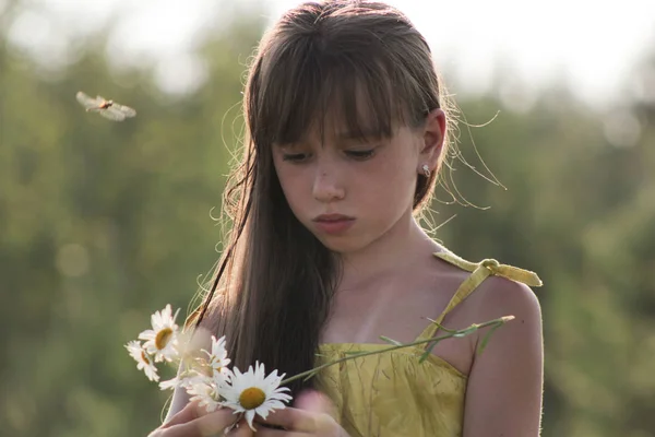 Niedliches Mädchen sammelt Blumen auf dem Feld - russisches Sommerdorf aus nächster Nähe — Stockfoto