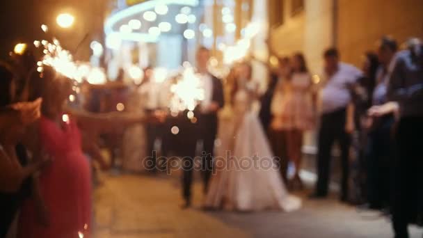 Wedding fireworks - sparkler in hands on a wedding - bride, groom and guests holding lights in, de-focused and slow-motion — Stock Video