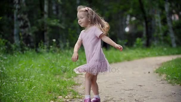 Kind spinnen en dansen in het park, slow-motion — Stockvideo