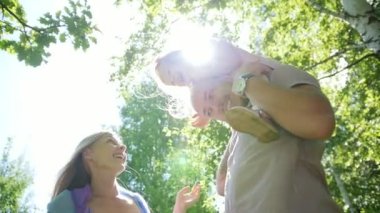 Baba, anne ve kızı içinde eğleniyor, güneşli park day, ağır çekim