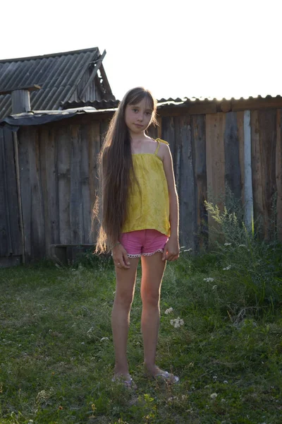 Chica adolescente con el pelo largo en el patio del campo, pueblo ruso — Foto de Stock