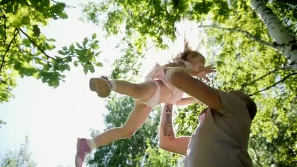 Vater wirft seine kleine Tochter im Park in Zeitlupe um — Stockvideo