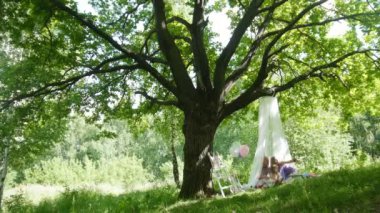 Baba, anne ve kızı büyük ağacın altında park - piknik aile