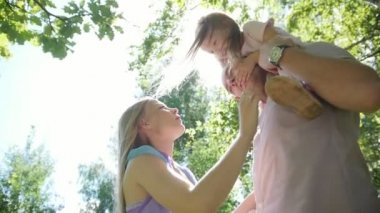 Baba, anne ve kızı içinde eğleniyor, güneşli park day, ağır çekim