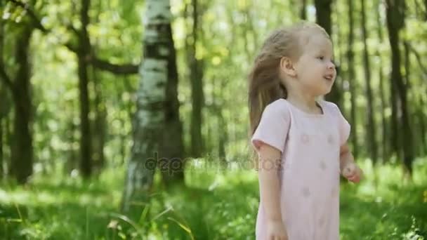 Adorable niña está caminando en el parque, en cámara lenta — Vídeos de Stock