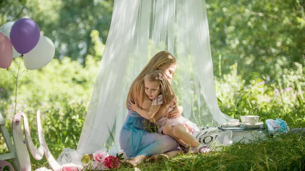 Moeder en dochter is knuffelen in park - picknick en verjaardag — Stockfoto