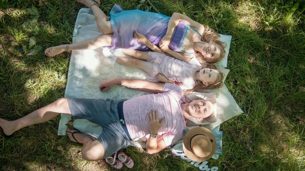 Familie in park op picknick - vader, moeder en dochter - bovenaanzicht — Stockfoto