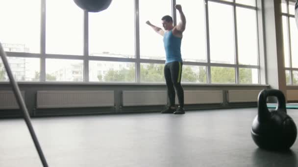 Fitness club - joven hombre fuerte haciendo ejercicios para el calentamiento en el gimnasio — Vídeos de Stock