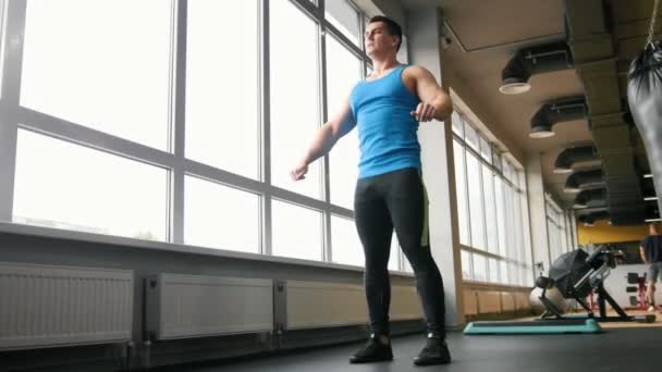 Musculoso joven haciendo ejercicios para el calentamiento en el gimnasio — Vídeos de Stock