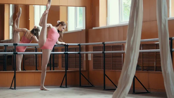 Hermosa chica muestra increíble flexibilidad de las piernas de la barra de ballet —  Fotos de Stock