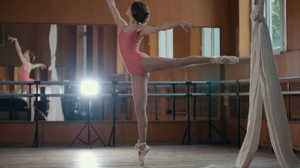 Menina acrobática jovem mostra a flexibilidade do corpo na barra de ballet — Fotografia de Stock
