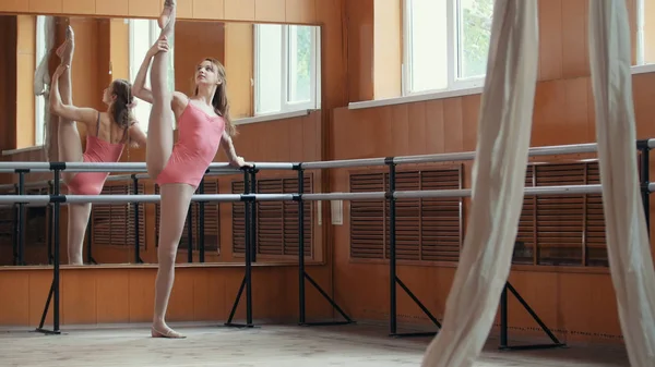 Hermosa chica muestra increíble flexibilidad de las piernas de la barra de ballet —  Fotos de Stock