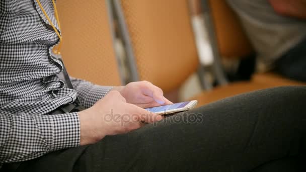 Hombre utiliza dispositivo digital sentado en el foro sobre la industria y la economía — Vídeos de Stock