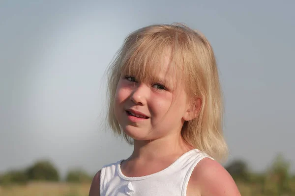 Niña rubia posando en el campo, pueblo de verano — Foto de Stock