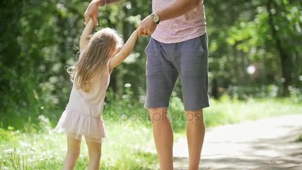 Dziecko dziewczynka z ojcem w parku - Tatuś jest spinning dziewczynka, zwolnionym tempie — Wideo stockowe