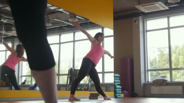Yoga im Fitnessclub - Trainer zeigt Fitnessgymnastik für Frauen, modernes Fitnessstudio — Stockvideo