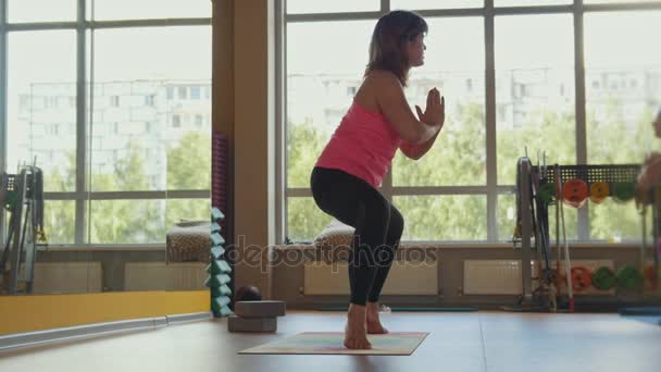 Nainen jooga valmentaja suorittaa harjoituksia kuntosalilla kunto oppitunti kypsä naisille — kuvapankkivideo