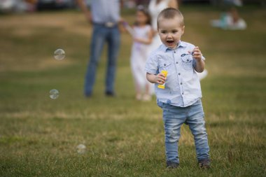 Park - küçük çocuk sabun köpüğü üfleme yürüyüş sırasında aile