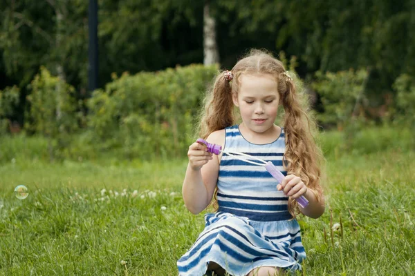 Niña jugando con burbuja de jabón en el parque de verano — Foto de Stock