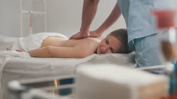 A mulher jovem está em uma mesa de massagem - terapia manual terapêutica — Fotografia de Stock