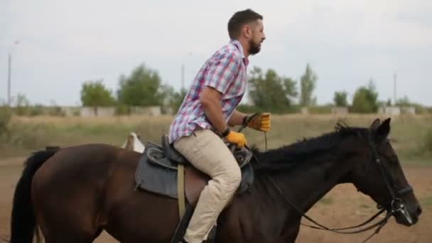 Homem barbudo está montando a cavalo - aula de equitação do hipódromo, câmera lenta — Vídeo de Stock