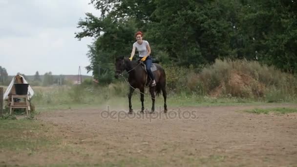 Röd korthårig flicka rider på hästryggen på dagtid - Rider lektion — Stockvideo