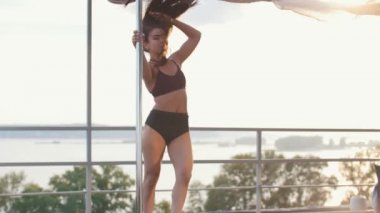 Güzel kız modeli çatıda - pole dans dans ediyor