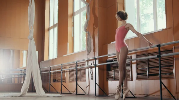 Молодая девушка изящно исполняет акробатические трюки в студии — стоковое фото