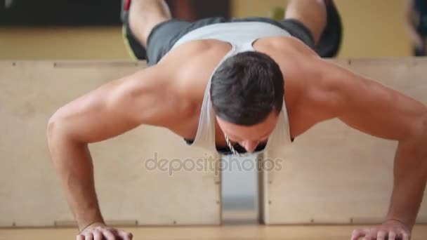 Silný muž kulturista - provádí push up v tělocvičně - pohled na plochu — Stock video