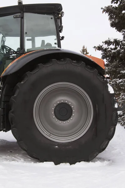 Neumático de ruedas de un tractor agrícola en el día de nieve de invierno — Foto de Stock