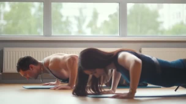 Pareja deportiva - chica y hombre haciendo flexiones juntos en el gimnasio - culturismo para la familia — Vídeos de Stock