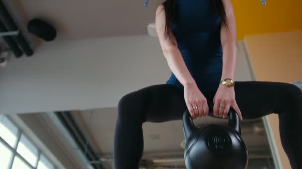 Ung flicka tränar gör knäböj med väga i gymmet, underifrån, slider — Stockvideo