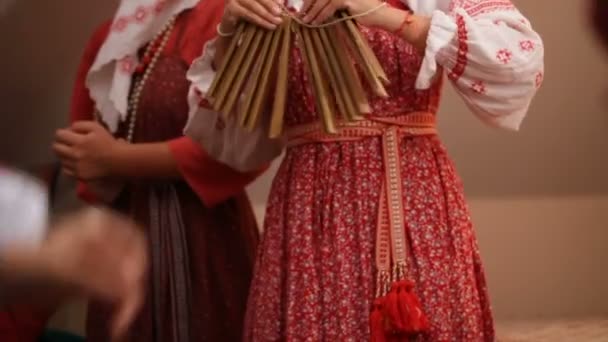 Русская народная музыкальная группа - женщина в традиционных костюмах играет на музыкальных инструментах - храповик, замедленная съемка — стоковое видео