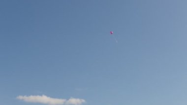Bir kırmızı hava balonu mavi gökte uçup