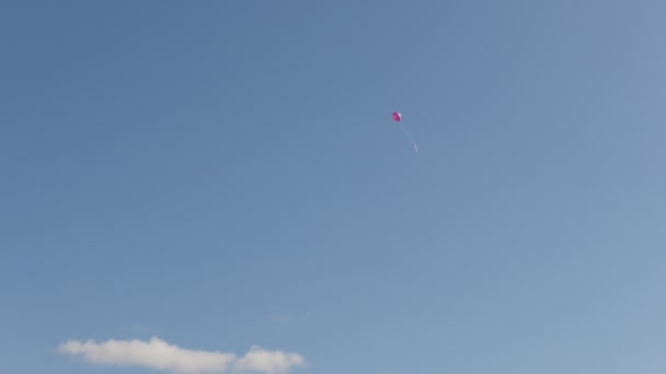 Egy piros hőlégballon elszáll a kék ég — Stock videók