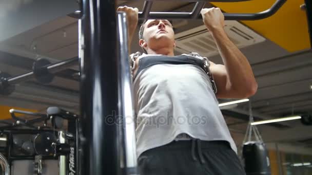 Fisiculturista no ginásio executa puxar para cima para bíceps com corrente de metal — Vídeo de Stock