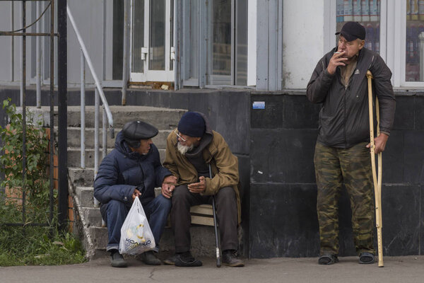 KAZAN, RUSSIA - 9 SEPTEMBER 2017: three homeless beggars men having a break near food shop