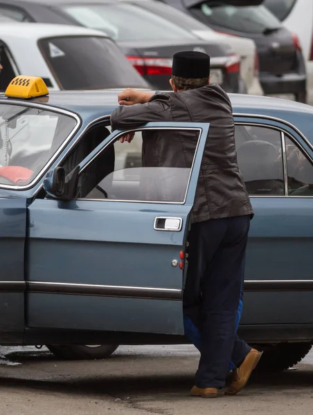 Russian illegal taxi and driver in tatar national hat, vertical — Stock Photo, Image