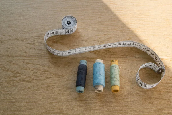 Stilleben nähen - Baumwollgarnspulen in verschiedenen Farben, Fingerhut, Nadel, Maßband — Stockfoto