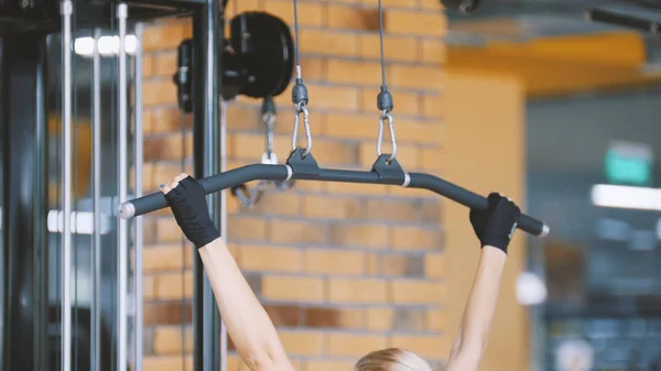 Fitness-club - mujer realiza ejercicios para las manos en el gimnasio —  Fotos de Stock